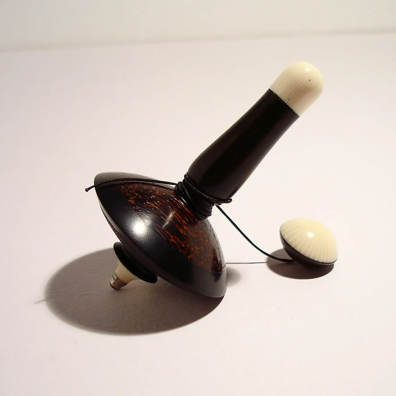 Filo Spinning Top in Ebony, Galalith and Black Palm
