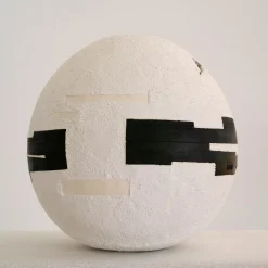 White Cement Sphere with Black Geometric Insertions