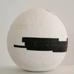 White Cement Sphere with Black Geometric Insertions