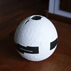 White Cement Sphere with Black Geometric Insertions